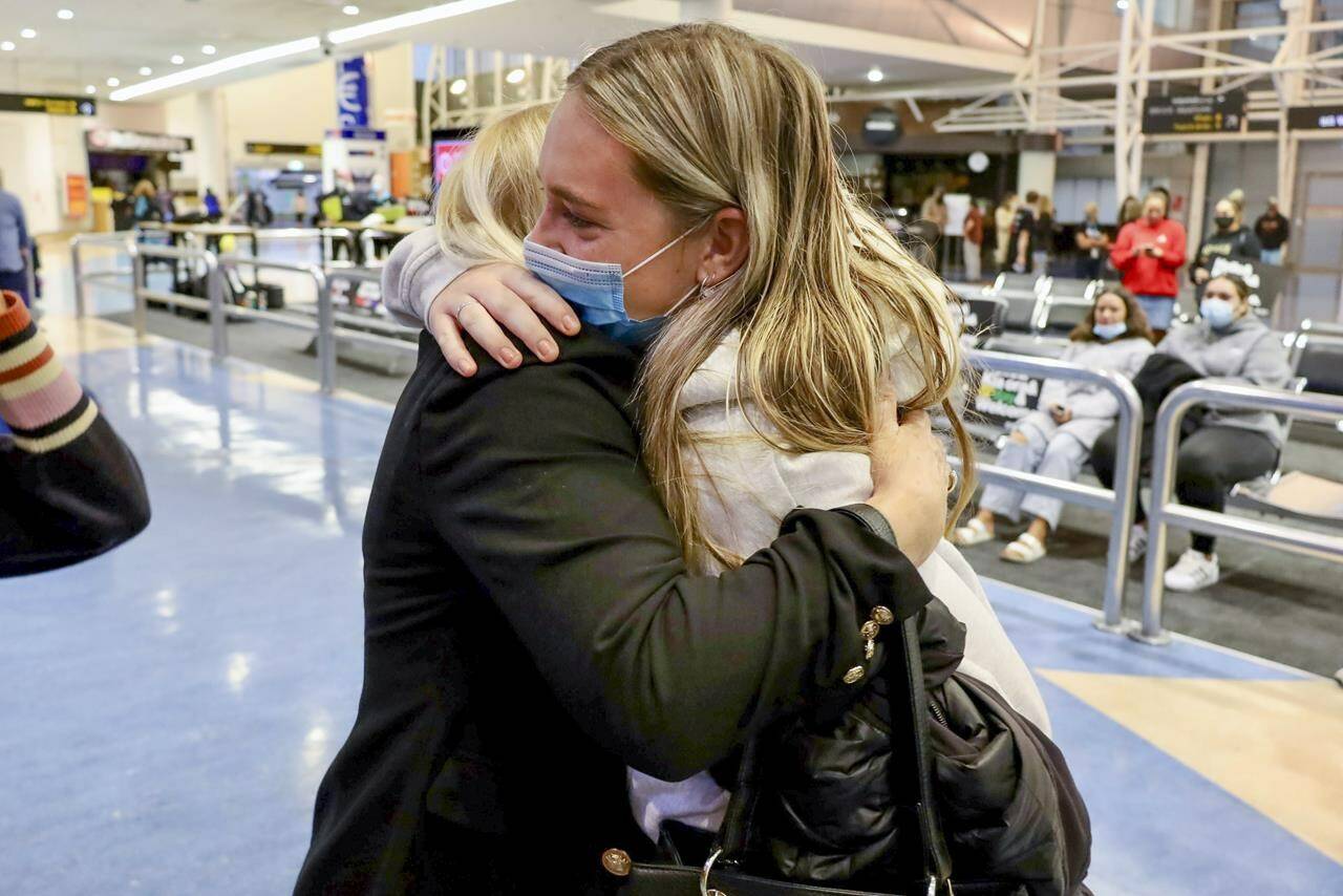 Families embrace after a flight from Los Angeles arrived at Auckland International Airport as New Zealand’s border opened for visa-waiver countries Monday, May 2, 2022. New Zealand welcomed tourists from the U.S., Canada, Britain, Japan and more than 50 other countries for the first time in more than two years as it dropped most of its remaining pandemic border restrictions. (Jed Bradley/New Zealand Herald via AP)