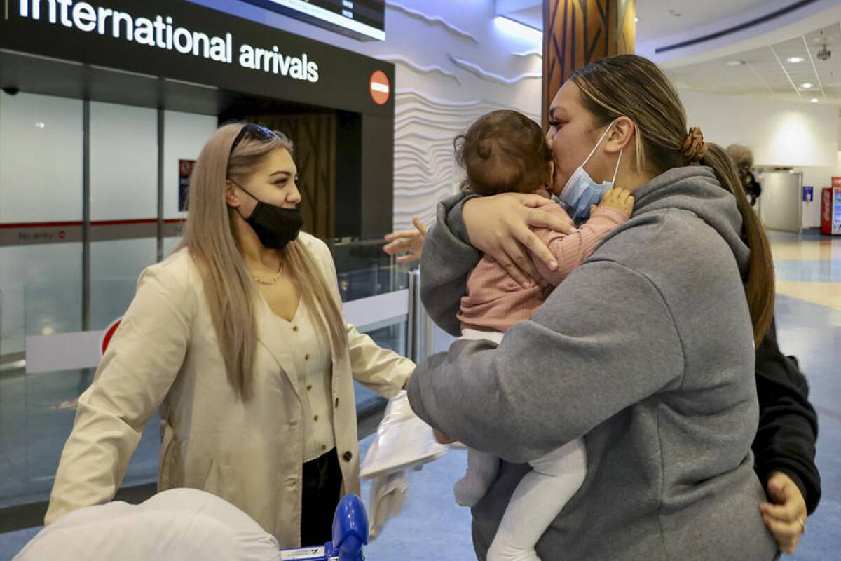 Families embrace after a flight from Los Angeles arrived at Auckland International Airport as New Zealand’s border opened for visa-waiver countries Monday, May 2, 2022. New Zealand welcomed tourists from the U.S., Canada, Britain, Japan and more than 50 other countries for the first time in more than two years as it dropped most of its remaining pandemic border restrictions. (Jed Bradley/New Zealand Herald via AP)