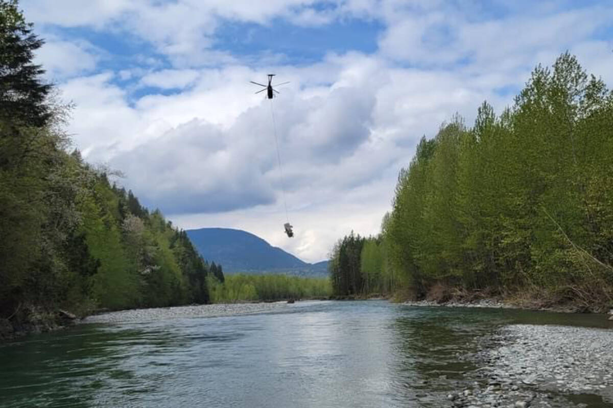 A helicopter on May 1, 2022 removes one of three vehicles washed into the Chilliwack River during the atmospheric rivers in November. (AJ Towing photo)