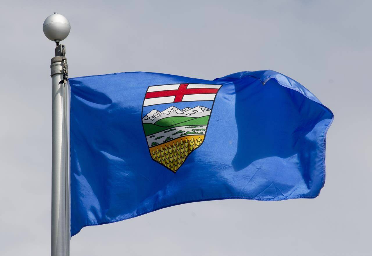 Alberta’s provincial flag flies on a flag pole in Ottawa, Tuesday, June 30, 2020. Police say a former Alberta teacher accused of recording at least 10 students changing their clothes at school has been charged with voyeurism and other offences. THE CANADIAN PRESS/Adrian Wyld