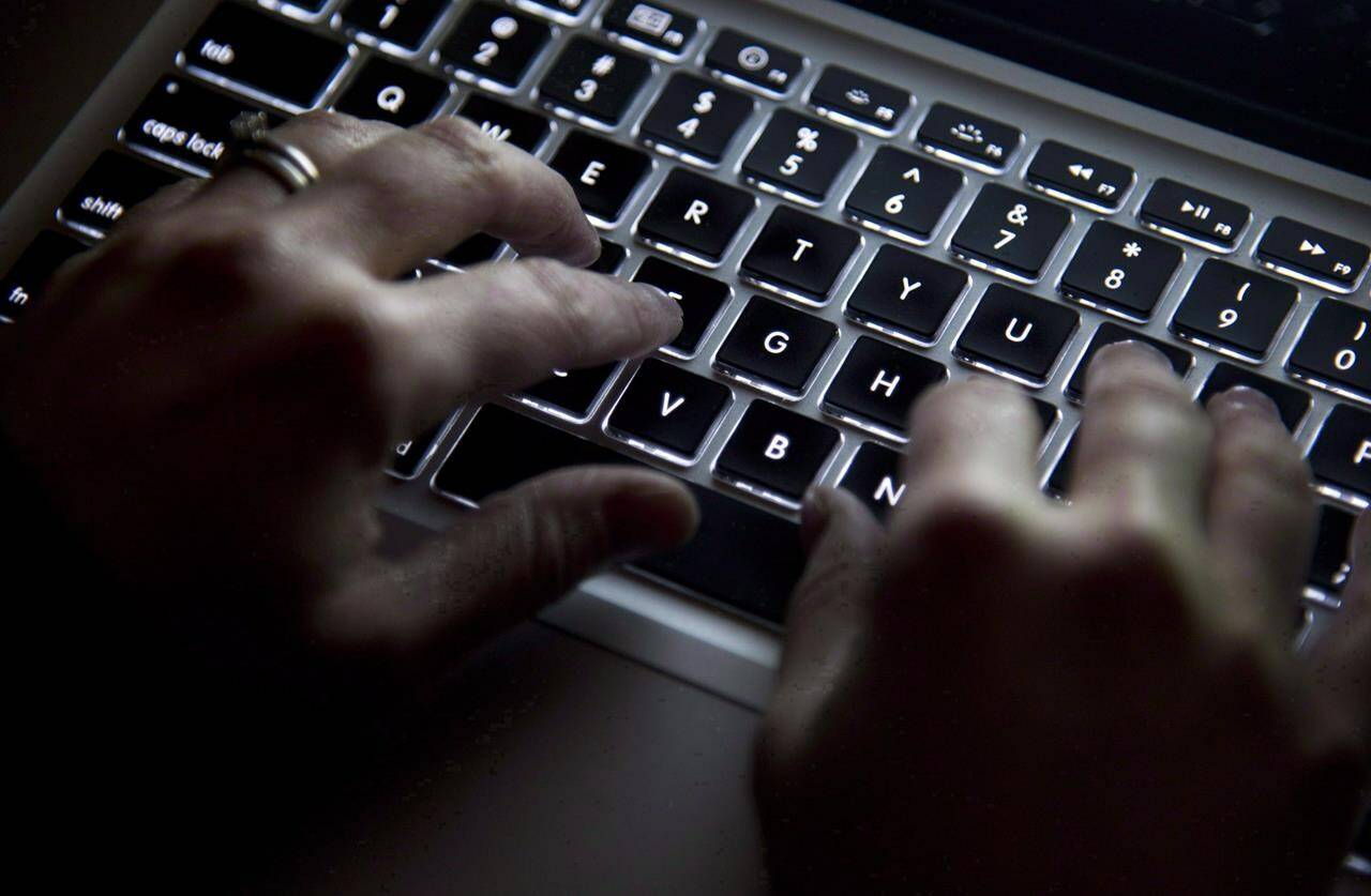 A woman uses her computer keyboard in North Vancouver, B.C., on December 19, 2012. Canada’s financial intelligence agency is warning that unregistered cash-transfer services are ripe for abuse by criminals trying to launder money and fund terrorist activities.THE CANADIAN PRESS/Jonathan Hayward