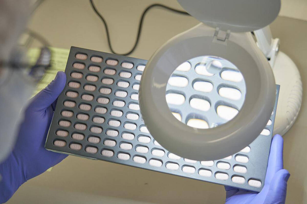 In this photo provided by Pfizer, a lab technician visually inspects COVID-19 Paxlovid tablet samples in Freiburg, Germany in December 2021. As more doctors prescribe Pfizer’s powerful COVID-19 pill, new questions are emerging about its performance, including why a small number of patients appear to relapse after taking the drug. (Pfizer via AP, File)