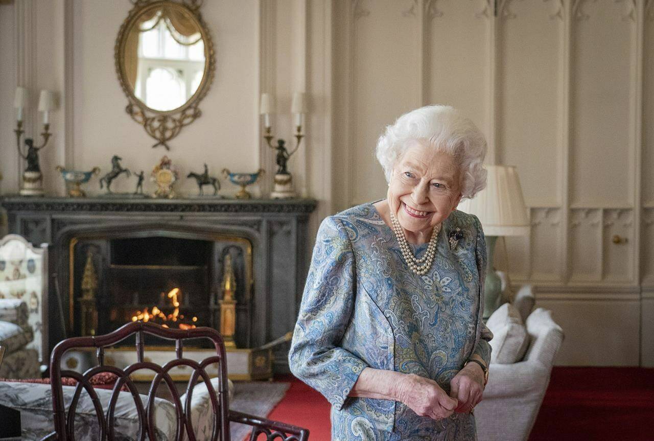 FILE - Britain’s Queen Elizabeth II smiles while receiving the President of Switzerland Ignazio Cassis and his wife Paola Cassis during an audience at Windsor Castle in Windsor, England, April 28, 2022. Buckingham Palace says Queen Elizabeth II will not attend the opening of Parliament on Tuesday amid ongoing mobility issues. The palace said in a statement Monday, May 9 that the decision was made in consultation with her doctors and that the 96-year-old monarch had “reluctantly’’ decided not to attend.(Dominic Lipinski/Pool Photo via AP, file)