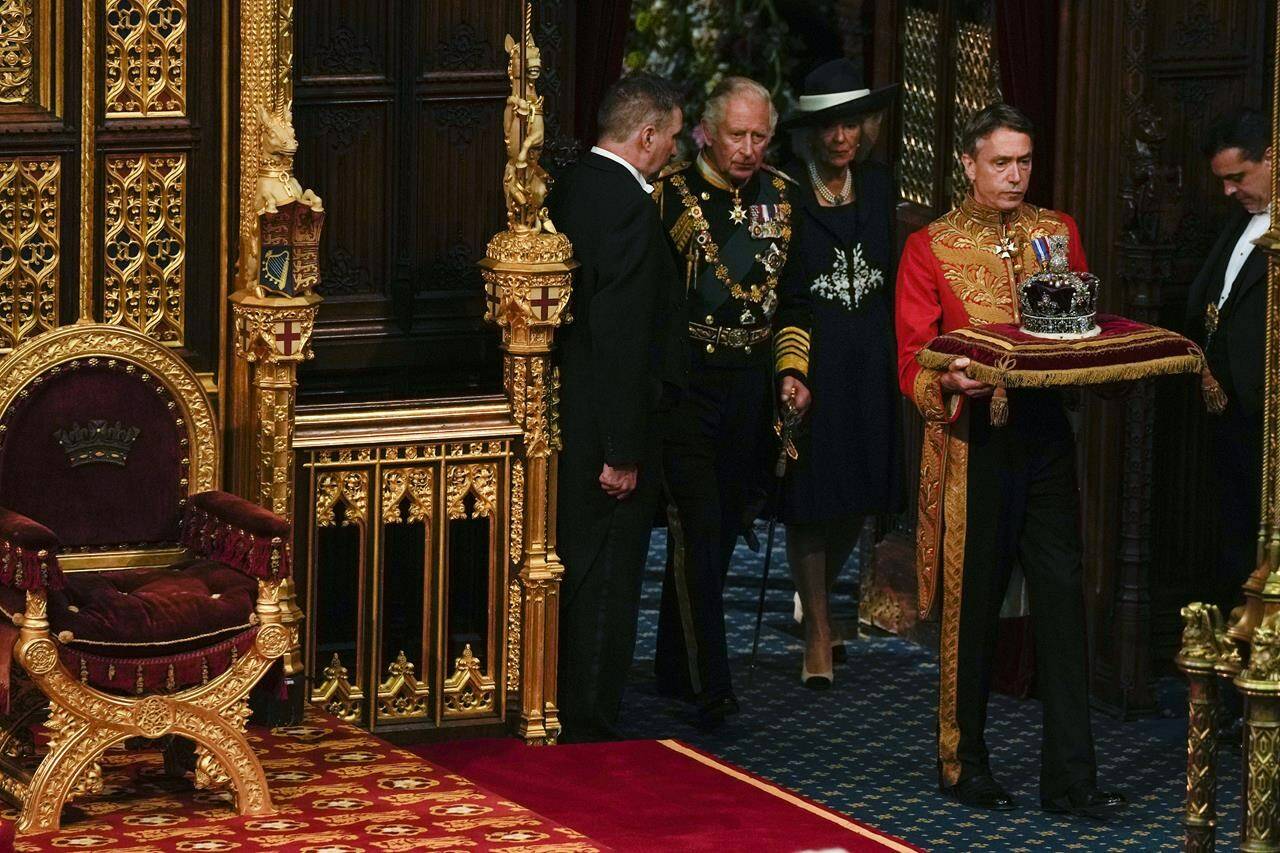 Prince Charles and Camilla Duchess of Cornwall, follow the Queen’s crown as they arrive for the State Opening of Parliament, at the Palace of Westminster in London, Tuesday, May 10, 2022. Queen Elizabeth II did attend amid ongoing mobility issues. (AP Photo/Alastair Grant, Pool)