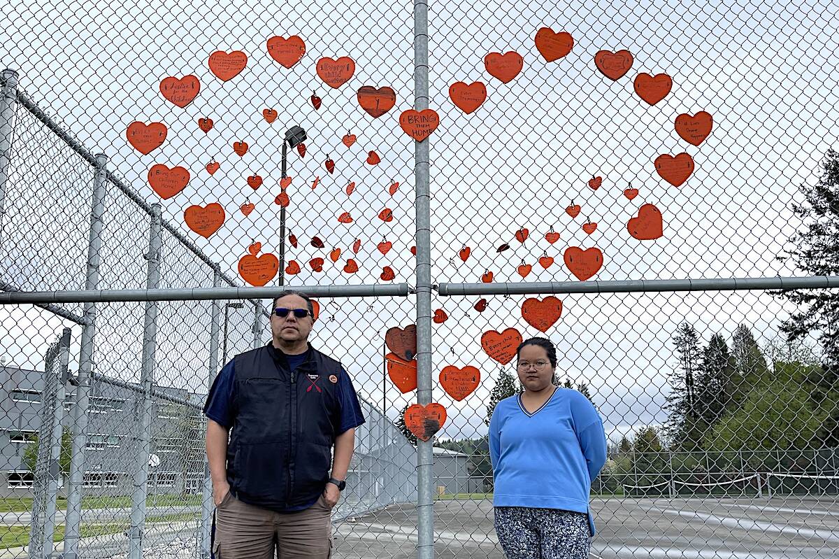 Chilliwack Secondary teacher Rick Joe and Grade 9 student Geralee George in front of the vandalized orange hearts display near the entrance. (Jennifer Feinberg/ Chilliwack Progress)