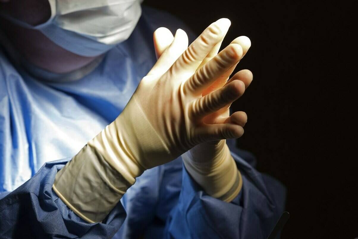 A doctor prepares for a surgical procedure at a hospital in Washington on June 28, 2016. The latest data release by the Canadian Institute for Health Information shows Canadians still struggled with long wait times for surgeries last year compared to the days before COVID-19. THE CANADIAN PRESS/AP-Molly Riley