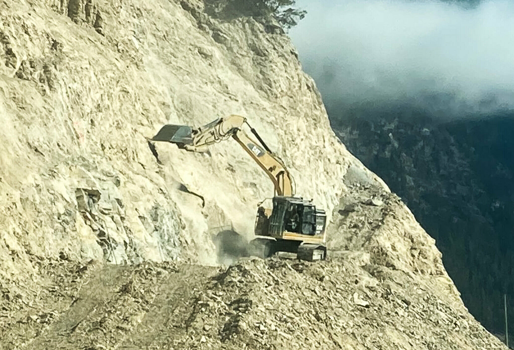 Construction is well underway on some of the permanent infrastructure surrounding Phase 4 of the Kicking Horse Canyon Project. Pictured above is an excavator working on the project, scaling the rock face at ���Cut 2��� overlooking the future Lynx viaduct in the western portion of the project zone. (MoTI photo)