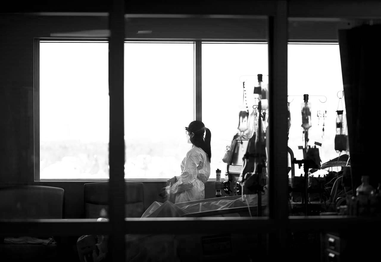 A registered nurse takes a moment to look outside while attending to a ventilated COVID-19 patient in the intensive care unit. THE CANADIAN PRESS/Nathan Denette