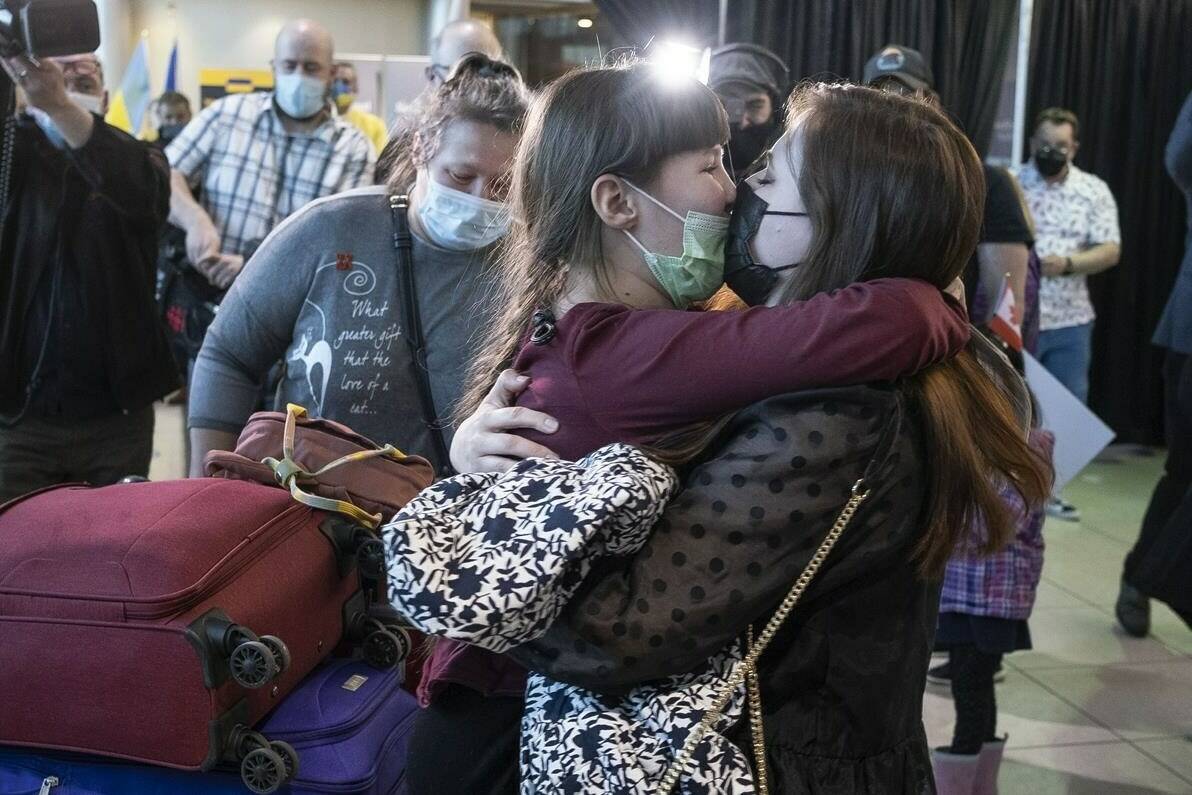 Nine year old Zoriana greets her sister, Sofiia, as her and their mother, Natalia, arrive from Ukraine in St. John’s, Monday, May 9, 2022. Newfoundland and Labrador received its first plane load of refugees from Ukraine. THE CANADIAN PRESS/Greg Locke