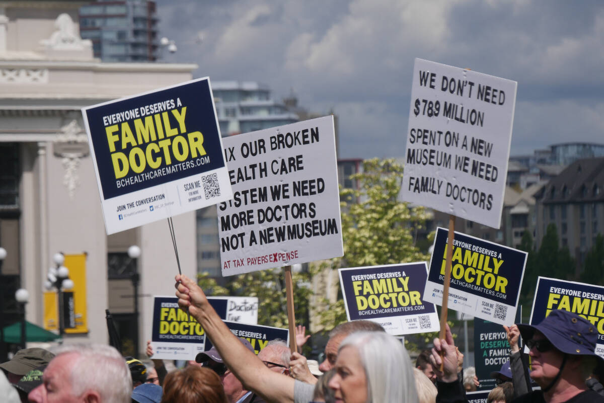 Dozens display signs at the BC Health Care Matters rally on May 19, 2022, at the legislature for World Family Doctor Day. (Evert Lindquist/News Staff)