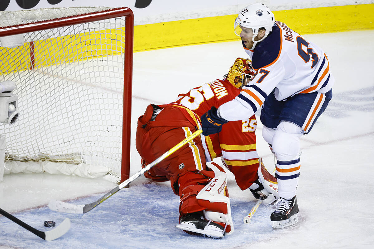 Edmonton Oilers centre Connor McDavid, right, scores on Calgary Flames goalie Jacob Markstrom during second period NHL second round playoff hockey action in Calgary, Alta., Friday, May 20, 2022. THE CANADIAN PRESS/Jeff McIntosh