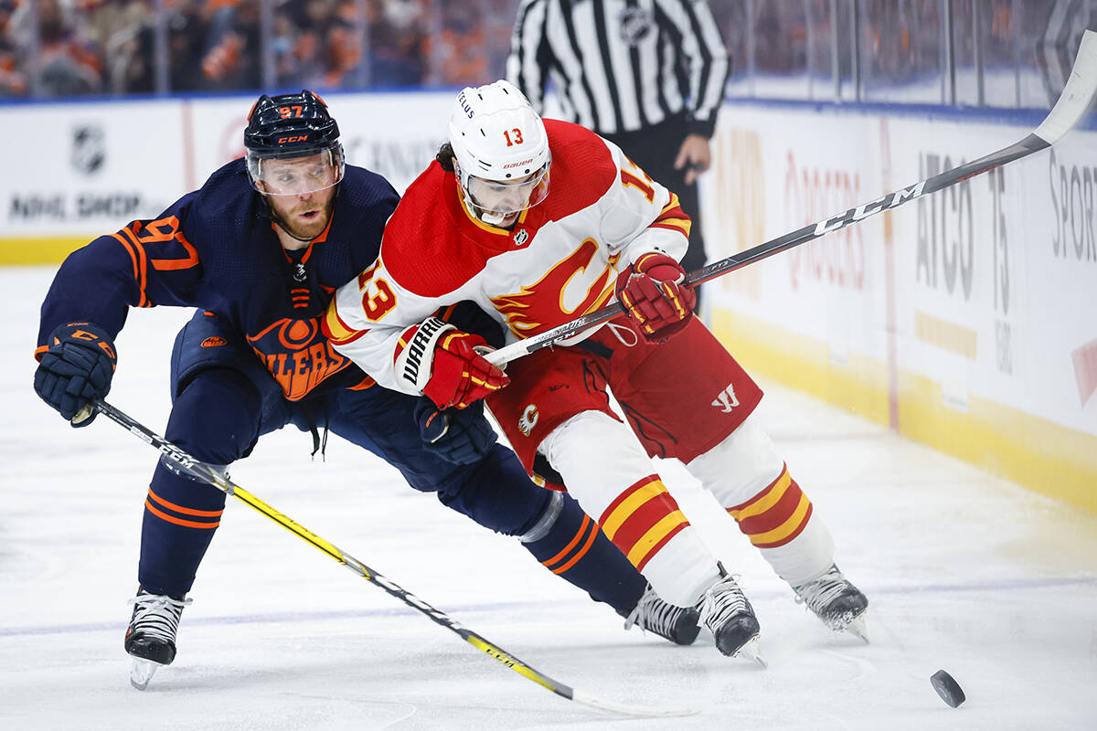 Calgary Flames forward Johnny Gaudreau, right, is checked by Edmonton Oilers centre Connor McDavid during first period NHL second-round playoff hockey action in Edmonton, Tuesday, May 24, 2022.THE CANADIAN PRESS/Jeff McIntosh