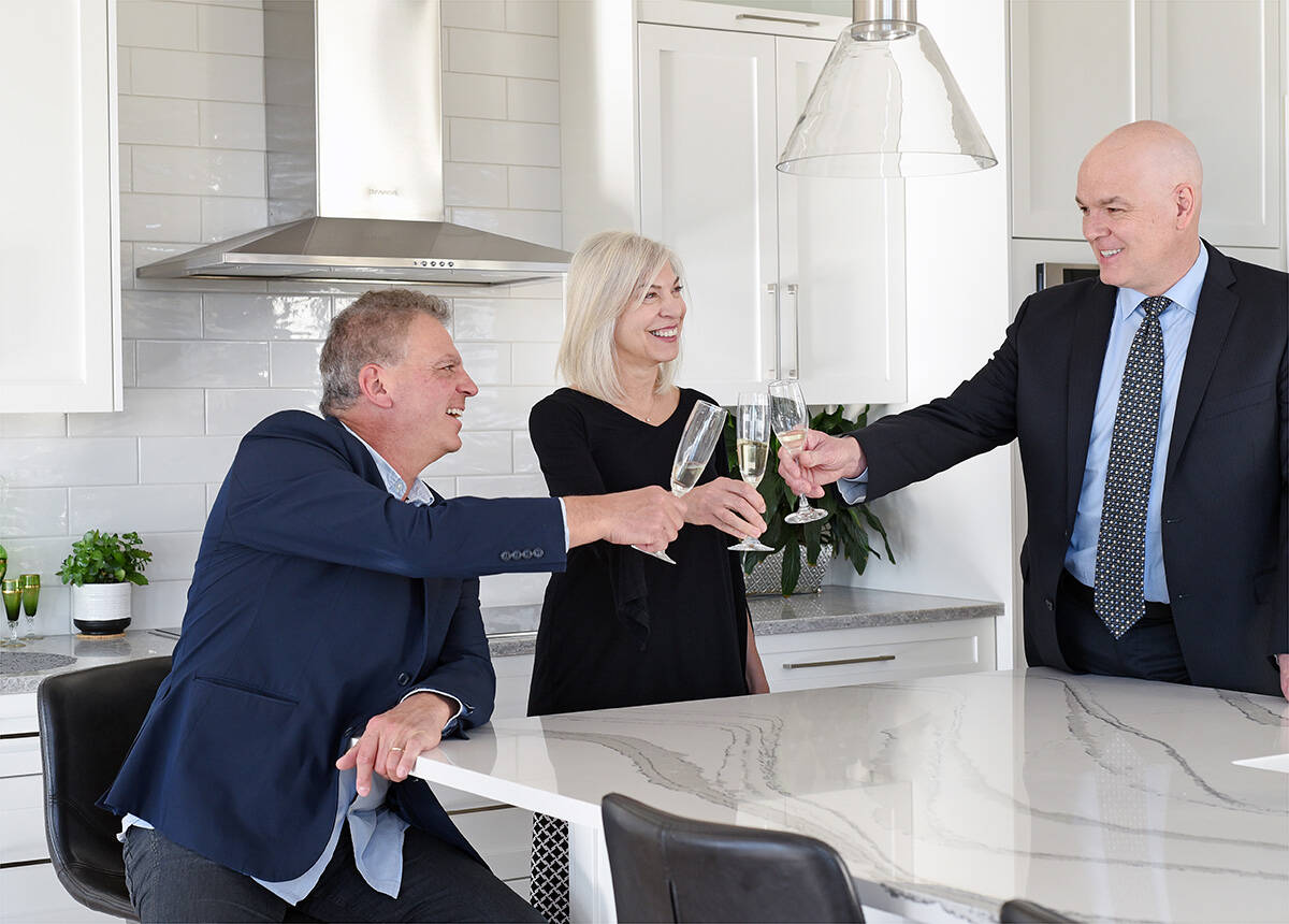 (L-R) Max Carbone, Anna Carbone and Dean Desrosiers of Century 21 Assurance Realty have a kitchen discussion in a Kelowna home. Don Denton photography.