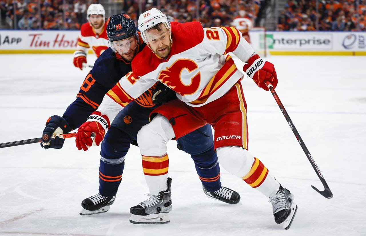 Calgary Flames forward Trevor Lewis, right, holds back Edmonton Oilers winger Zach Hyman during third period NHL second-round playoff hockey action in Edmonton, Tuesday, May 24, 2022. THE CANADIAN PRESS/Jeff McIntosh