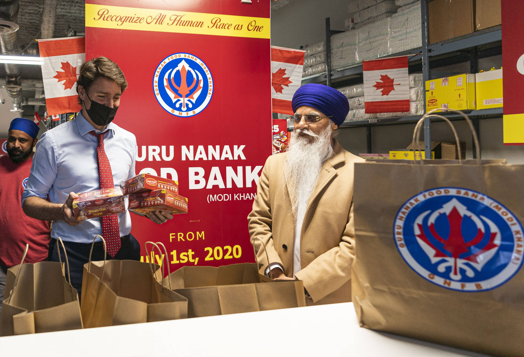 Prime Minister Justin Trudeau gathers some tea for a food hamper during a visit to the Guru Nanak Food Bank in Surrey, B.C. on Tuesday May 24, 2022. THE CANADIAN PRESS/Rich Lam