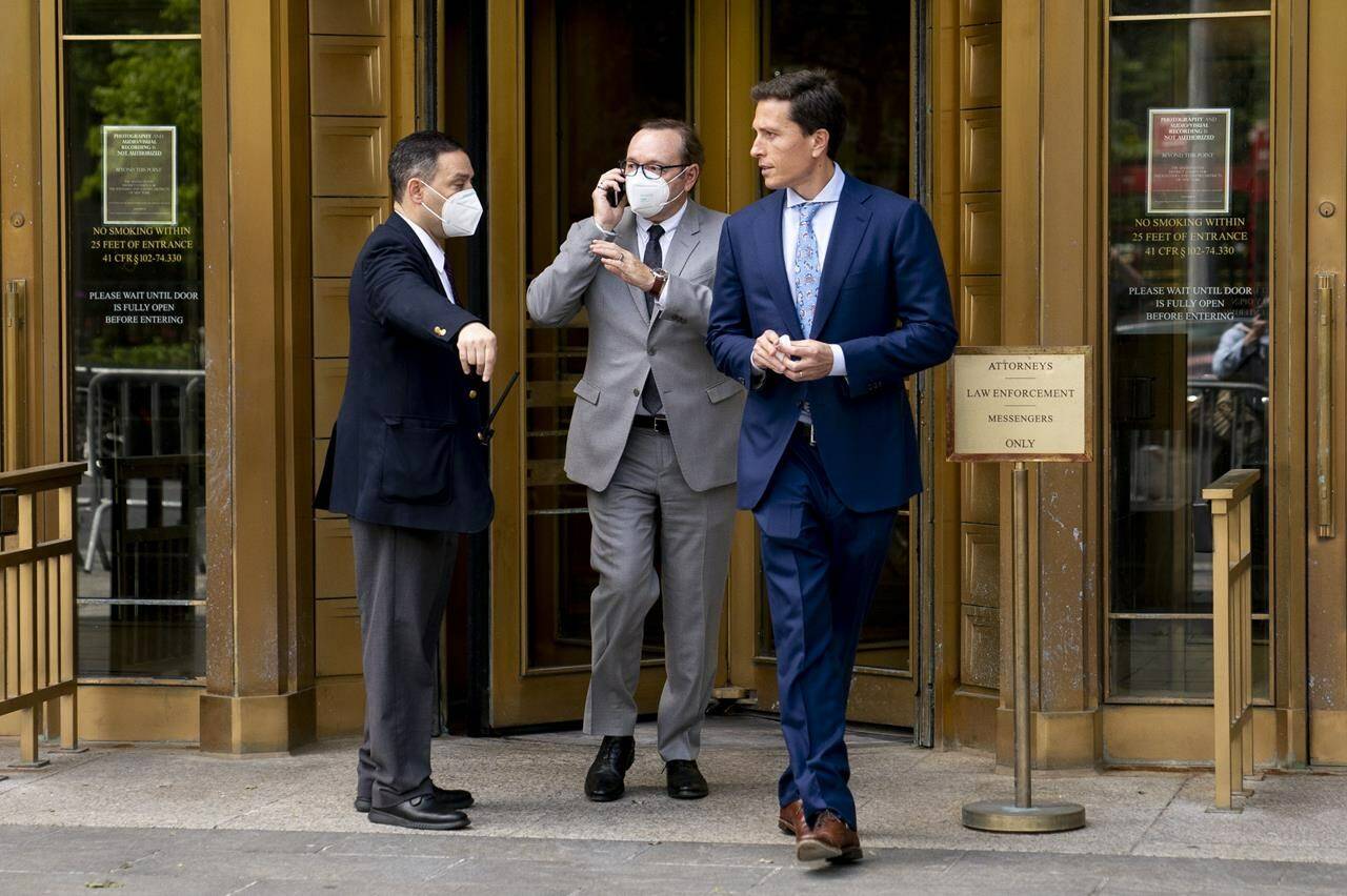 Kevin Spacey, center, leaves court after testifying in a civil lawsuit, Thursday, May 26, 2022, in New York. British prosecutors have charged Spacey with four counts of sexual assault against three men. The 62-year-old double Academy Award winner was questioned by British police in 2019 about claims by several men that he had assaulted them. The U.K. charges were announced Thursday, as Spacey was testifying in a courtroom in New York City in a civil lawsuit. (AP Photo/John Minchillo)