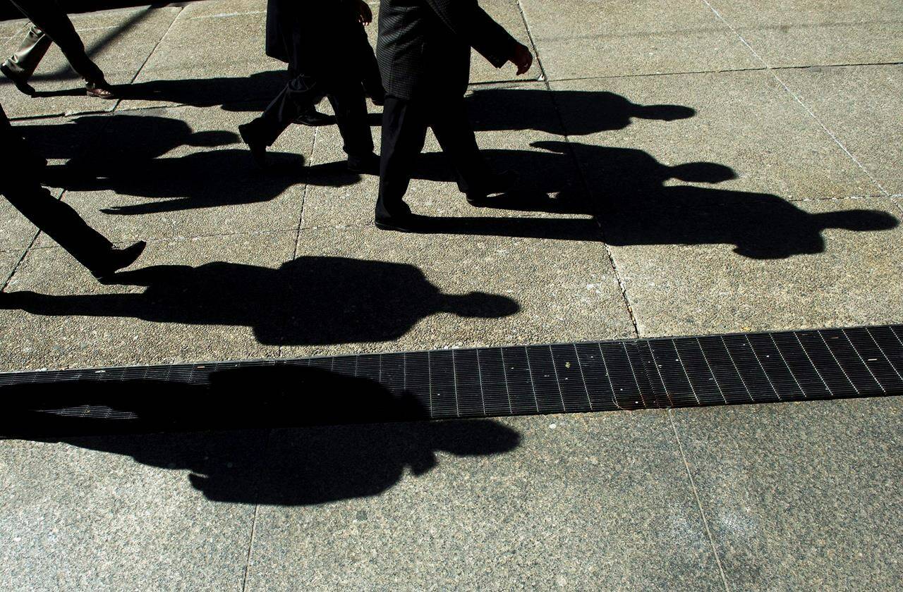 People cast their shadows as they walk in Toronto on Monday, Feb. 27, 2012. Canada’s auditor general has released a report on access to benefits among hard-to-reach populations.THE CANADIAN PRESS/Nathan Denette