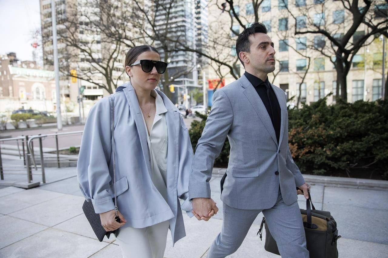 Canadian musician Jacob Hoggard arrives alongside his wife Rebekah Asselstine, for his sex assault trial at the Toronto courthouse on Tuesday, May 10, 2022 in Toronto. The Canadian musician, who is currently awaiting a verdict in his sexual assault trial, has been charged in another alleged sexual assault.THE CANADIAN PRESS/Cole Burston