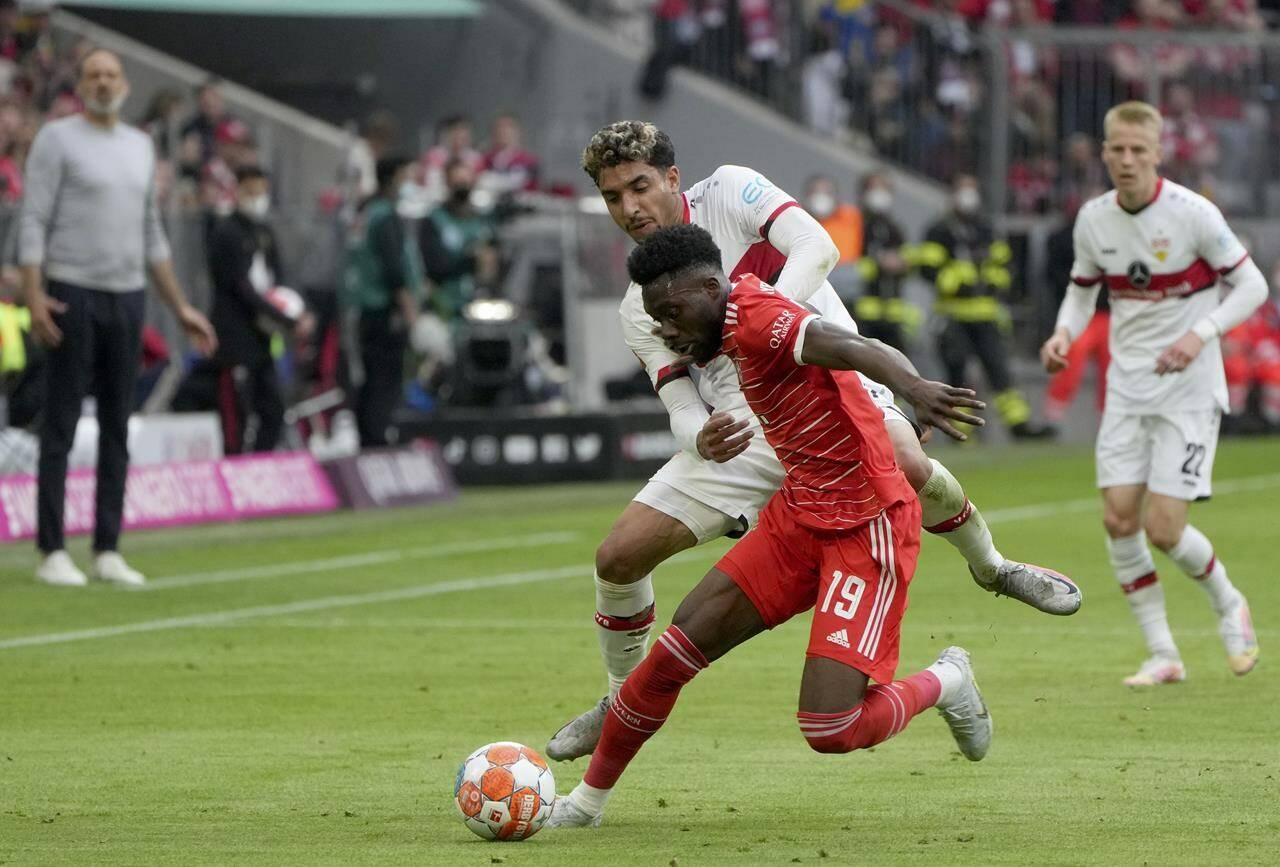Bayern's Alphonso Davies, front, duels for the ball with Stuttgart's Omar Marmoush during the German Bundesliga soccer match between Bayern Munich and Stuttgart, at the Allianz Arena, in Munich, Germany, Sunday, May 8, 2022. (AP Photo/Michael Probst )