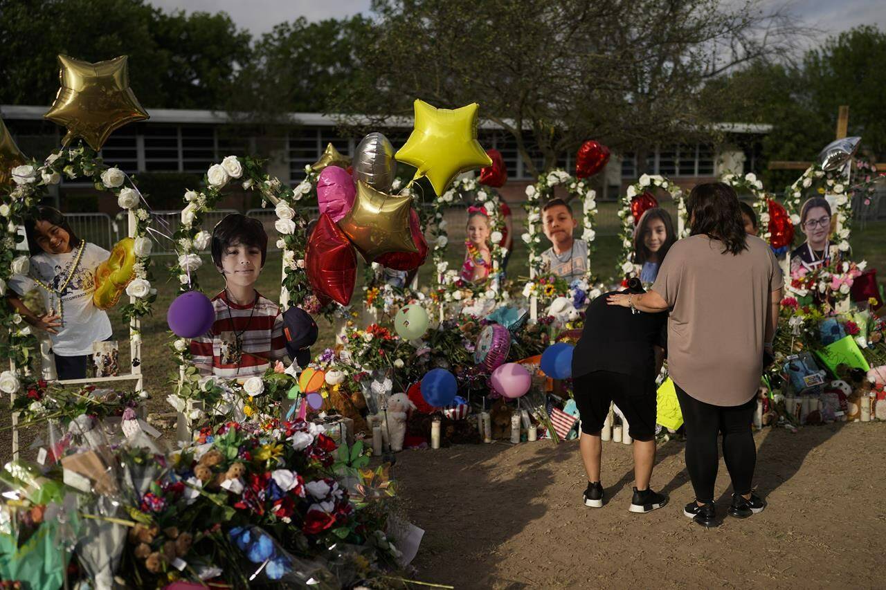 Jolean Olvedo, left, weeps while being comforted by her partner Natalia Gutierrez at a memorial for Robb Elementary School students and teachers who were killed in last week’s school shooting in Uvalde, Texas, Tuesday, May 31, 2022. (AP Photo/Jae C. Hong)