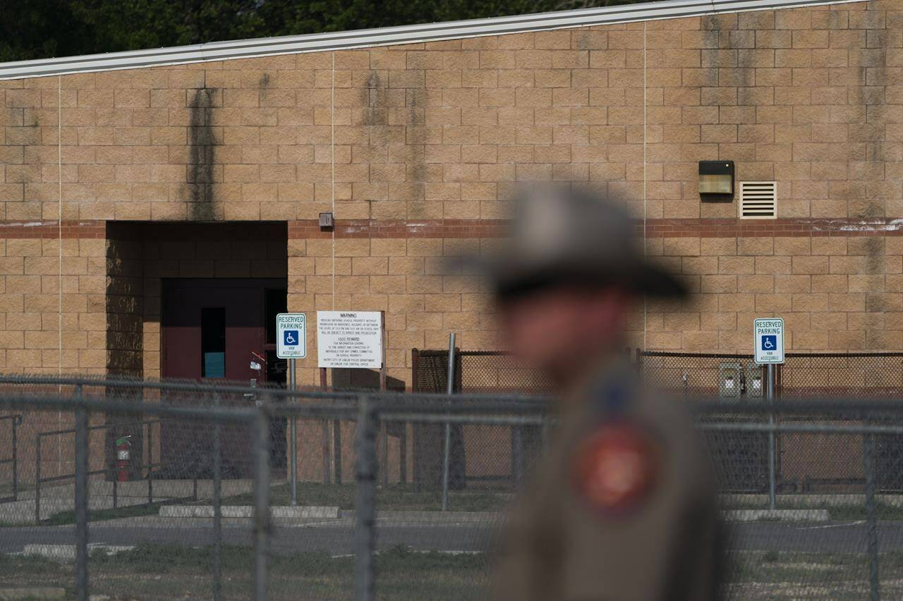 A back door at Robb Elementary School, where a gunman entered through to get into a classroom in last week’s shooting, is seen in the distance in Uvalde, Texas, Monday, May 30, 2022. (AP Photo/Jae C. Hong)
