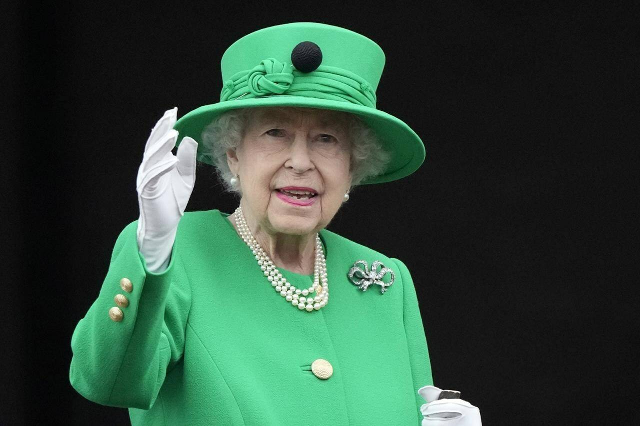 Queen Elizabeth II waves to the crowd during the Platinum Jubilee Pageant at the Buckingham Palace in London, Sunday, June 5, 2022, on the last of four days of celebrations to mark the Platinum Jubilee. THE CANADIAN PRESS/AP/Frank Augstein