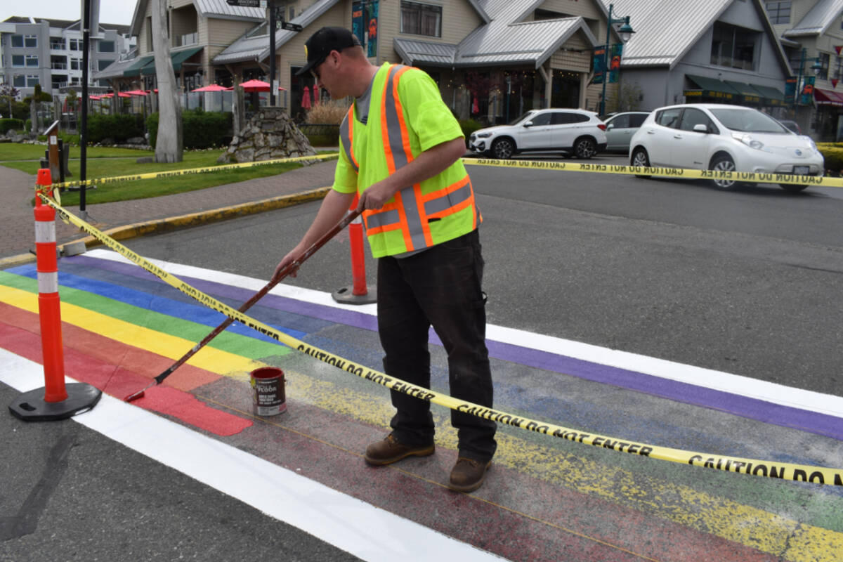 Andrew Lohr, facilities maintenance supervisor with the Town of Sidney retouches the Pride-themed crosswalk at the entrance of Sidney’s Beacon Park on June 1 at the start of Pride Month. (Wolf Depner/News Staff)