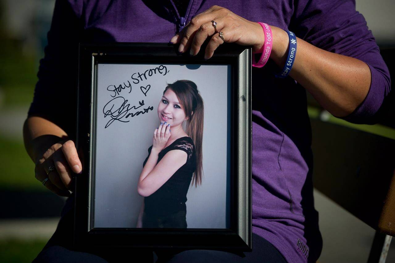 Carol Todd holds a photograph of her late daughter Amanda Todd signed by U.S. singer Demi Lovato with the words “Stay Strong” in Port Coquitlam, B.C., on Sunday October 5, 2013. The Dutch man accused of extorting and harassing British Columbia teenager Amanda Todd more than a decade ago has pleaded not guilty to five criminal charges. THE CANADIAN PRESS/Darryl Dyck
