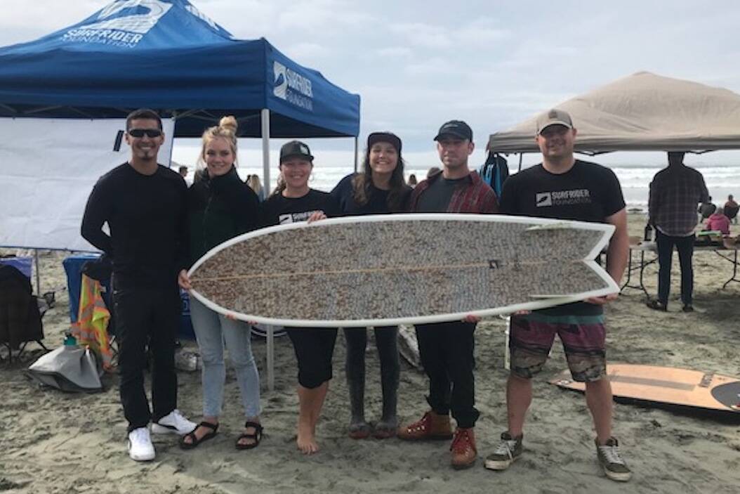 Surfrider Pacific Rim core crew hold the ‘Dart Board’, a surfboard made with cigarette butts by Ucluelet shaper Jesse Jones. (Submitted photo)