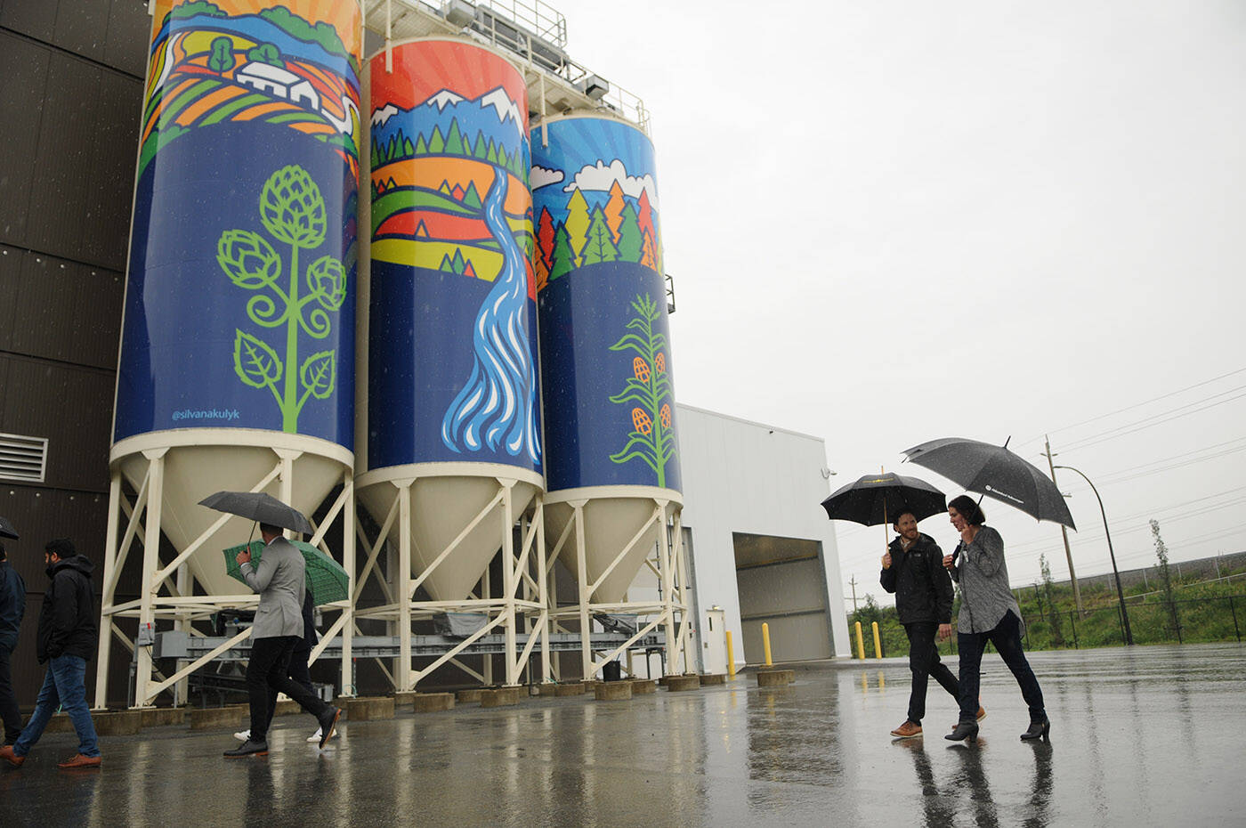 Chilliwack artist Silvana Kulyk (right) walks past her public art piece ‘Gifts of Nature’ which was installed on silos outside the Molson Coors Fraser Valley Brewery and unveiled on Thursday, June 9, 2022. (Jenna Hauck/ Chilliwack Progress)
