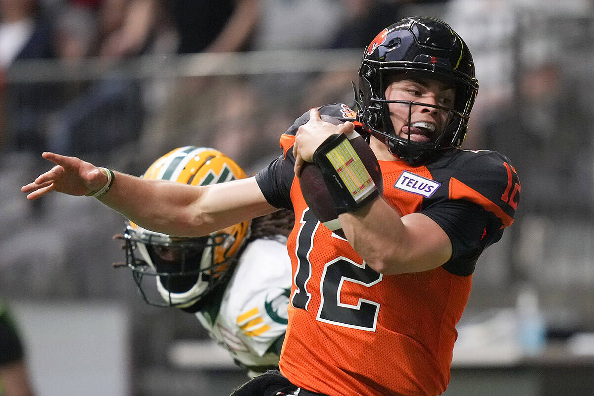 B.C. Lions quarterback Nathan Rourke (12) is pushed out of bounds by Edmonton Elks’ Jalen Collins as he runs with the ball during the first half of CFL football game in Vancouver, on Saturday, June 11, 2022. THE CANADIAN PRESS/Darryl Dyck