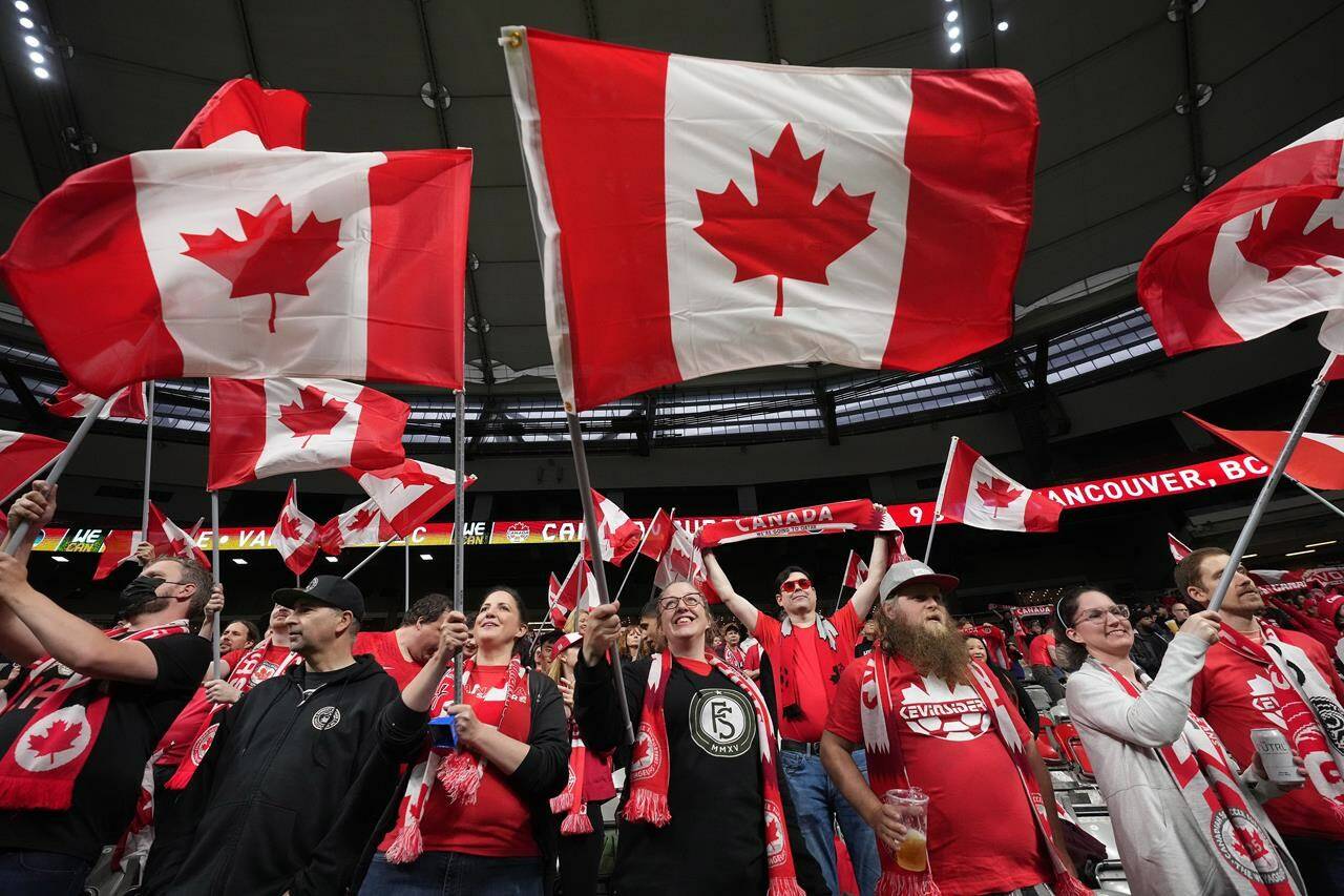 Fans wave Canadian flags before Canada and Curacao play a CONCACAF Nations League soccer match, in Vancouver, B.C., Thursday, June 9, 2022. THE CANADIAN PRESS/Darryl Dyck