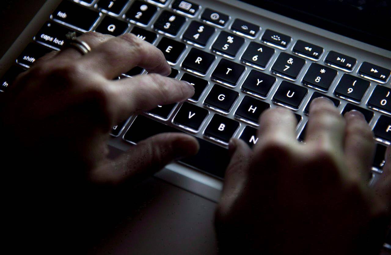 A woman uses her computer keyboard to type while surfing the internet in North Vancouver, B.C., Wednesday, Dec. 19, 2012. Businesses and other private-sector organizations would be required to report ransomware incidents and other cyberattacks to the government under a federal bill to be tabled today. THE CANADIAN PRESS/Jonathan Hayward