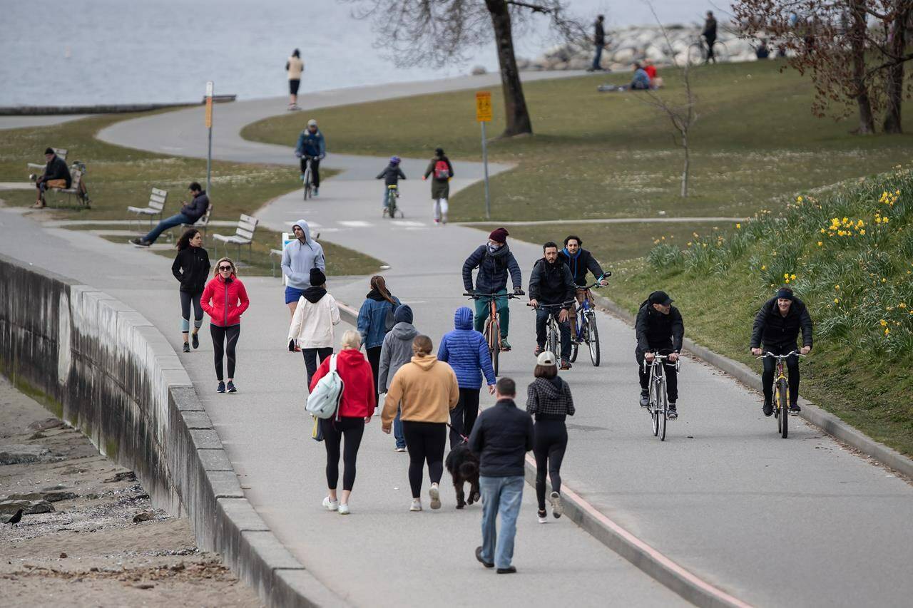 People walk and cycle on the seawall between English Bay and Sunset Beach, in Vancouver, on Sunday, March 22, 2020. An extensive new survey data suggests Canadians have more trust in their institutions and their neighbours since the COVID-19 pandemic. THE CANADIAN PRESS/Darryl Dyck