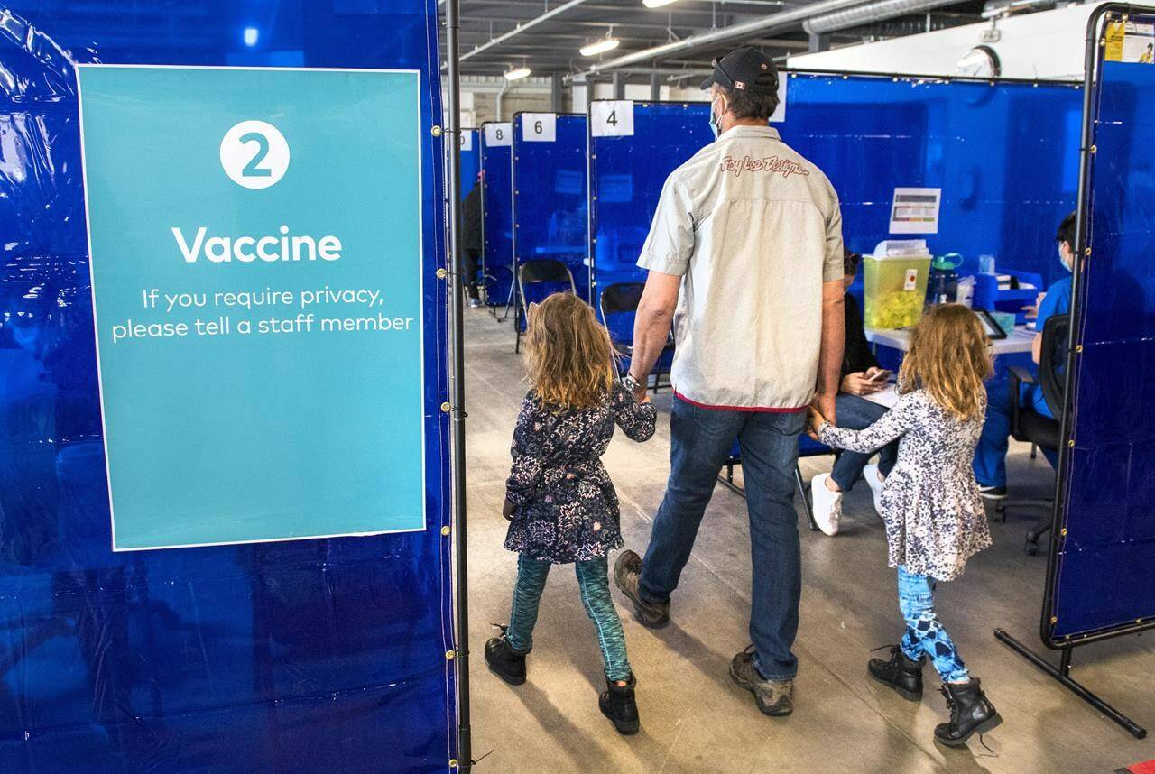 A man arrives with two young girls for his shot at the COVID-19 vaccination clinic at the Ontario Food Terminal in Toronto on Tuesday May 11, 2021. Federal officials say regulators should reach a decision about whether to approve Canada’s first COVID-19 vaccine for infants and preschoolers in coming weeks as the U.S. prepares to roll out tot-sized shots. THE CANADIAN PRESS/Frank Gunn