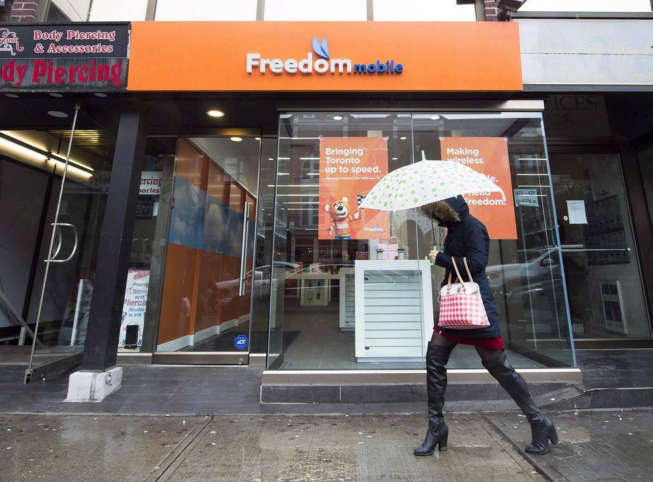 A women walks past the new rebranding sign of Freedom Mobile in Toronto on Thursday, November 24, 2016. Globalive Capital says it has gone straight to Shaw Communications Inc. with its $3.75 billion offer for wireless carrier Freedom Mobile due to a lack of engagement from Rogers Communications Inc. THE CANADIAN PRESS/Nathan Denette