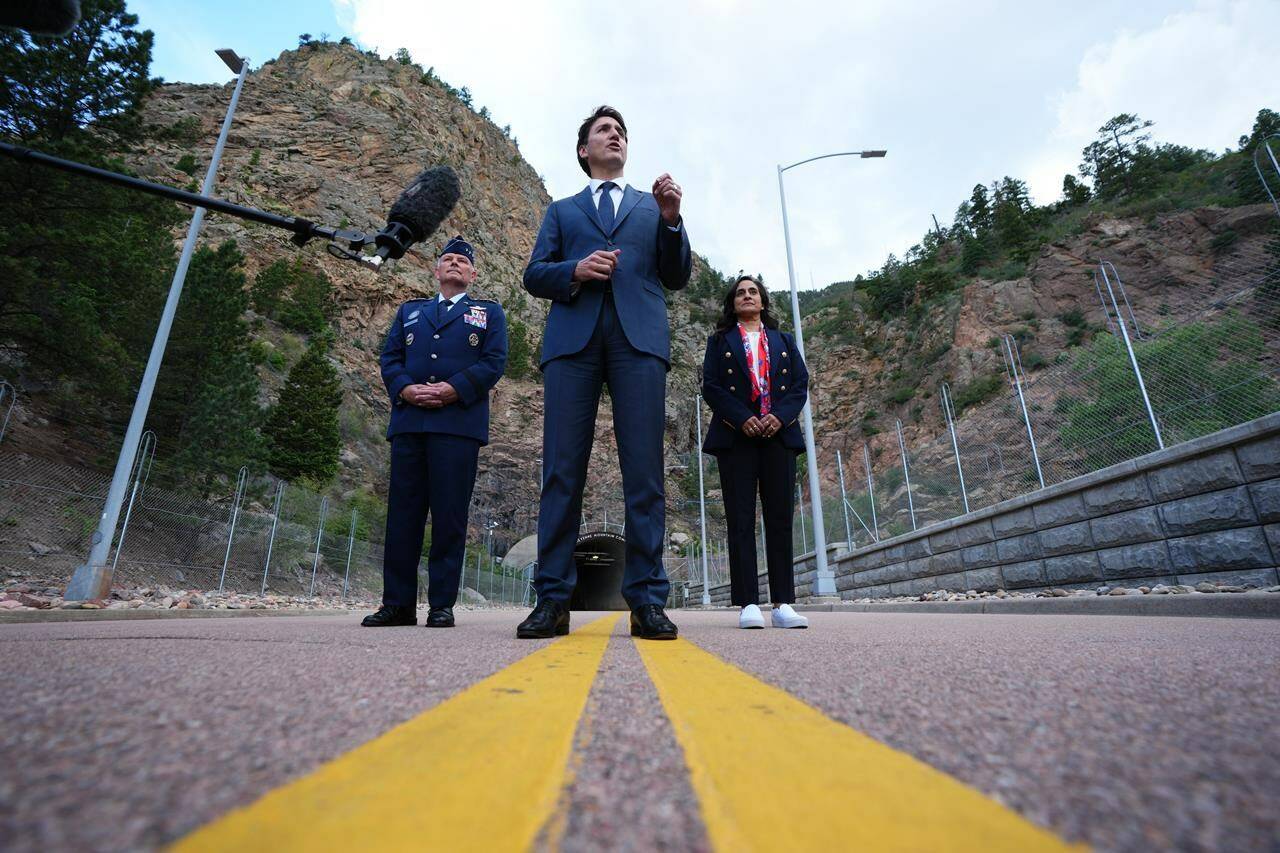 Canadian Prime Minister Justin Trudeau, centre, speaks to members of the media as Gen. Glen VanHerck, Commander of United States Northern Command and North American Aerospace Defense Command and Canadian Minister of National Defence Anita Anand look on at the Cheyenne Mountain Space Force Station facility in Colorado Springs, Colo., on Tuesday, June 7, 2022. THE CANADIAN PRESS/Sean Kilpatrick