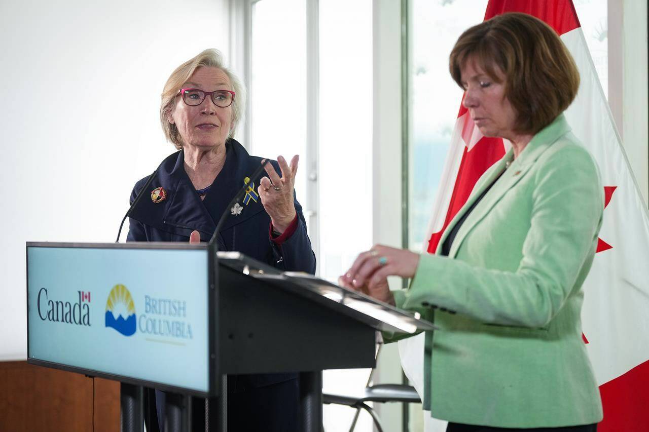 Federal Minister of Mental Health and Addictions and Associate Minister of Health Carolyn Bennett, back left, speaks as B.C. Minister of Mental Health and Addictions Sheila Malcolmson listens during a news conference after British Columbia was granted an exemption to decriminalize possession of some illegal drugs for personal use, in Vancouver, on Tuesday, May 31, 2022. As drug users in British Columbia will not be arrested or charged for carrying up to 2.5 grams of illicit drugs starting next year, experts explain why the federal government is being asked to decriminalize drugs in order to stem deaths linked to the drug toxicity crisis in Canada, and what decriminalization means. THE CANADIAN PRESS/Darryl Dyck