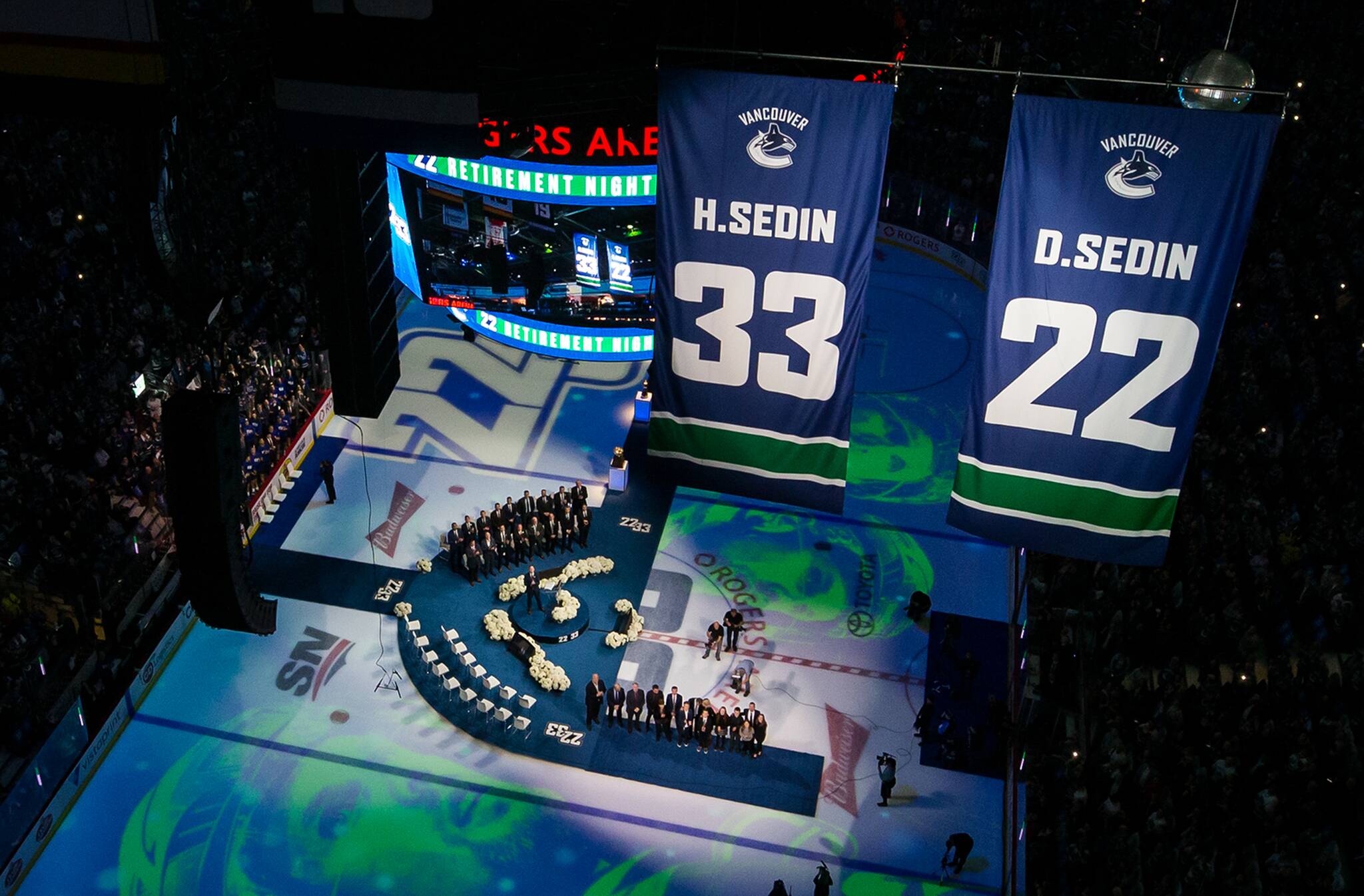 Former Vancouver Canucks players Henrik Sedin and his twin brother Daniel Sedin, both of Sweden, and their families watch as their numbers are raised to the rafters during a jersey retirement ceremony before an NHL hockey game in Vancouver, on Wednesday February 12, 2020. THE CANADIAN PRESS/Darryl Dyck