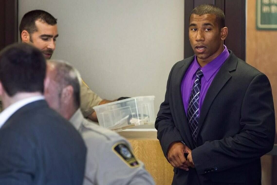 Former Canadian Football League wide receiver Joshua Boden, right, goes through security screening as he arrives at British Columbia Provincial Court in Vancouver, B.C., on Thursday July 26, 2012. A former Canadian Football League wide receiver convicted of killing his ex-girlfriend is expected to be sentenced in B.C. Supreme Court today. THE CANADIAN PRESS/Darryl Dyck