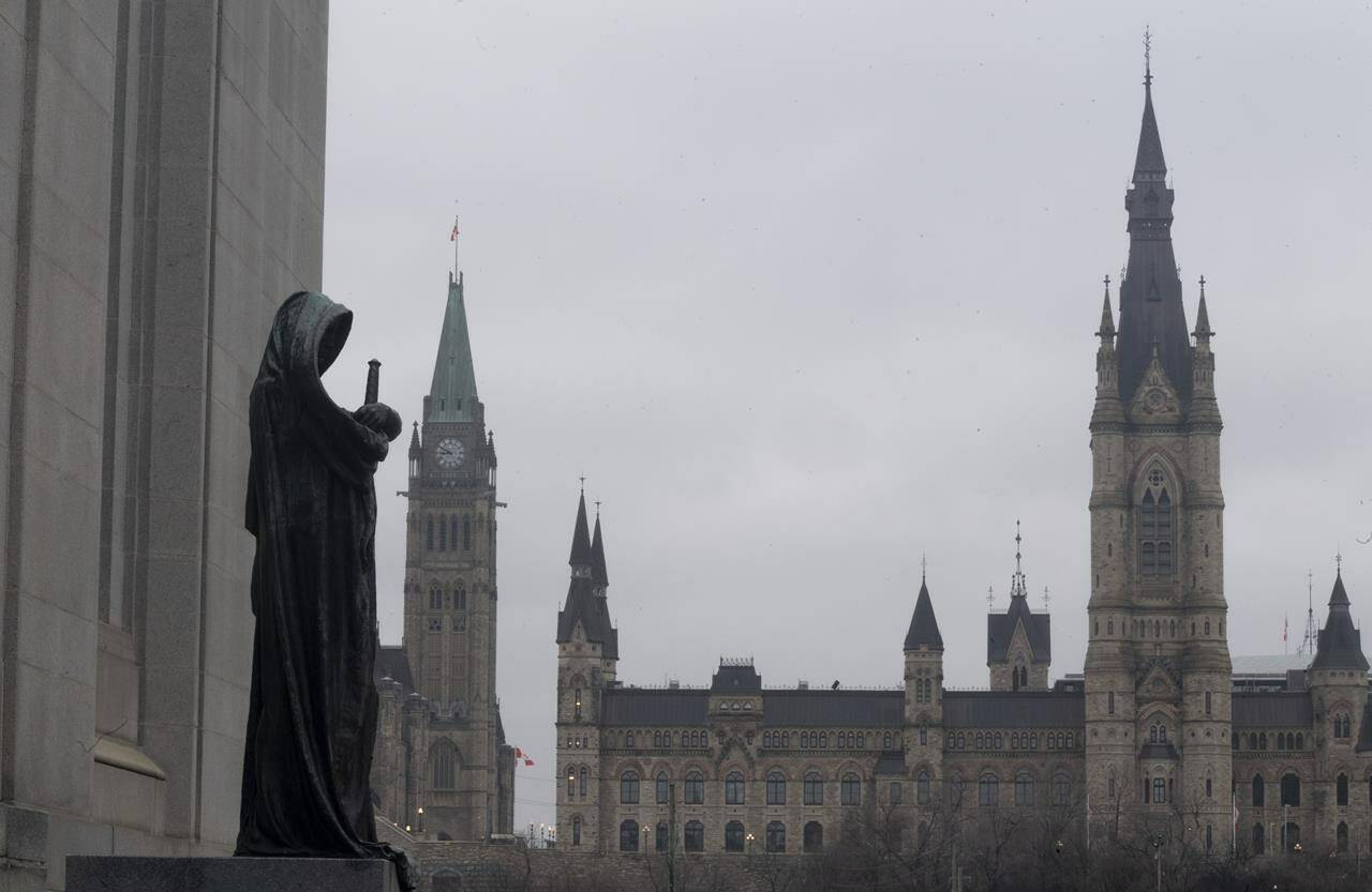 The statue representing justice looks out from the Supreme Court of Canada over the Parliamentary precinct in Ottawa on Thursday March 25, 2021. Canada’s top court has sent the case of two men convicted in the slayings of three family members back to the Alberta Court of Appeal. THE CANADIAN PRESS/Adrian Wyld