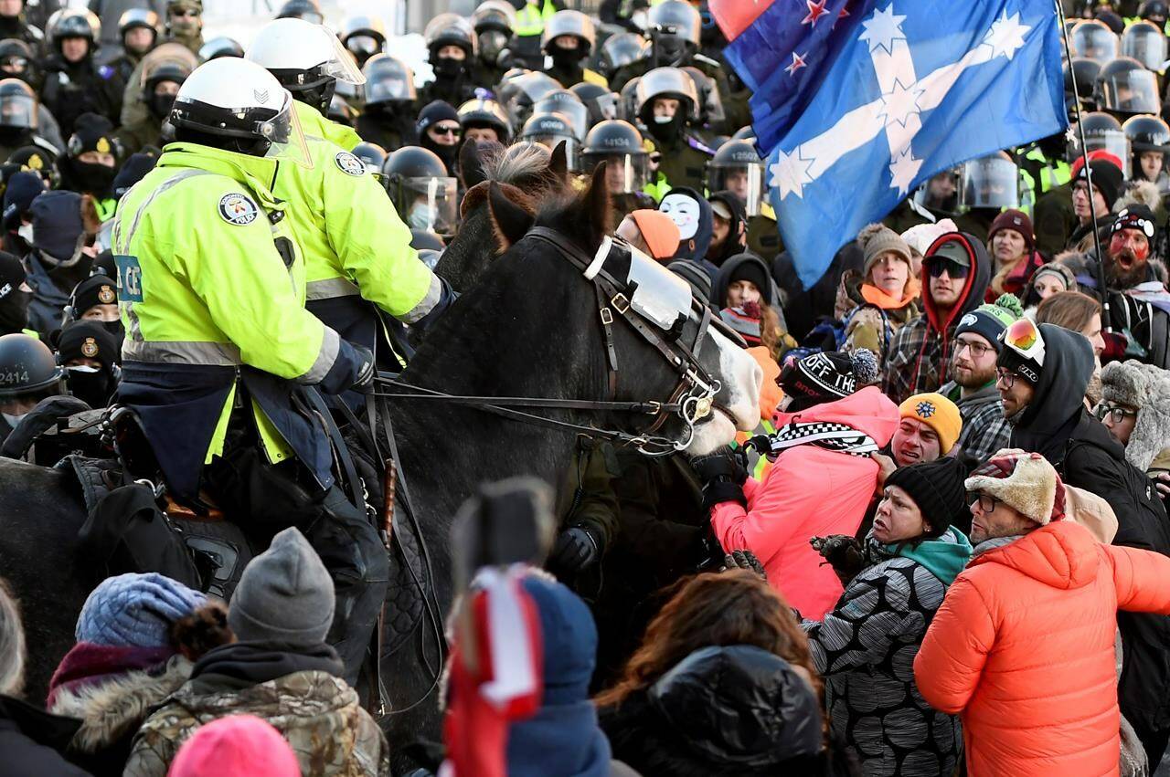 Protesters react as Toronto Police mounted unit charge to disperse as police take action to put an end to a protest, which started in opposition to mandatory COVID-19 vaccine mandates and grew into a broader anti-government demonstration and occupation, in Ottawa, Friday, Feb. 18, 2022. The commissioner of the inquiry examining Ottawa’s use of the Emergencies Act to bring an end to the so-called “Freedom Convoy” protest in February has granted standing to the organizers, police and representatives of all three levels of government. THE CANADIAN PRESS/Justin Tang