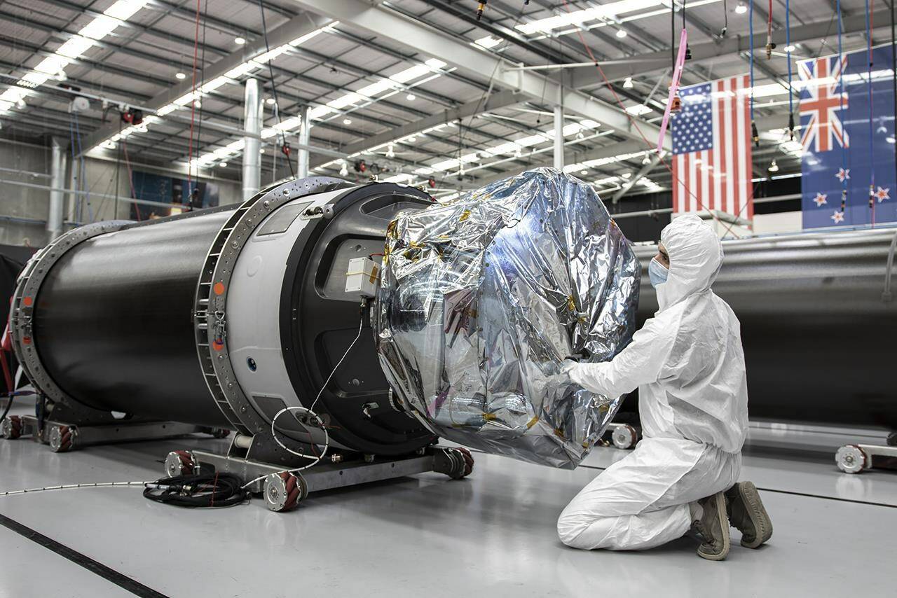In this photo released by Rocket Lab, a technician works on a component of Rocket Lab’s Electron rocket ahead of the launch on the Mahia peninsula in New Zealand on March 10, 2022. NASA plans to send up a satellite to track a new orbit around the moon which it hopes to use in the coming years to once again land astronauts on the lunar surface. (Rocket Lab via AP)