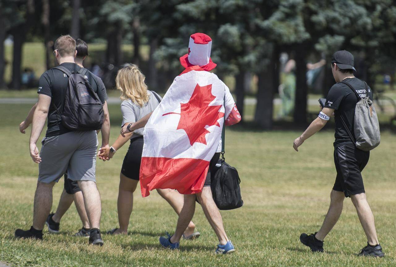 People arrive at a city park on Canada Day in Montreal, Wednesday, July 1, 2020. Canada Day celebrations are making a return after two years of scaled-down festivities, but some Canadians hoping to catch a traditional parade may be out of luck. THE CANADIAN PRESS/Graham Hughes