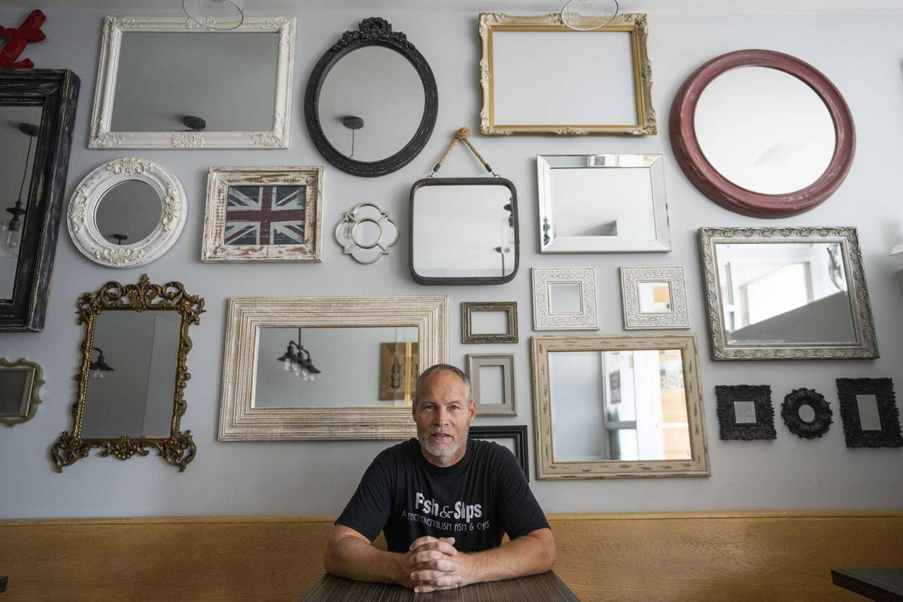 Paul Feather, vice-chair of the Collingwood Business Improvement Association and co-owner of Fish and Sips restaurant poses for a photo at his restaurant in Collingwood, Ont., on Thursday, June 30, 2022. When he opened Fish & Sips with his wife in 2015, Paul Feather found hiring to be one among many challenges of running a restaurant with long hours on the main drag of Collingwood, Ont. But after the COVID-19 pandemic struck and housing prices in vacation hotspots soared, the cod-and-calamari-slinging 49-year-old saw staffing as his No. 1 obstacle, due in no small part to a shortage of affordable rental units. THE CANADIAN PRESS/Andrew Lahodynskyj