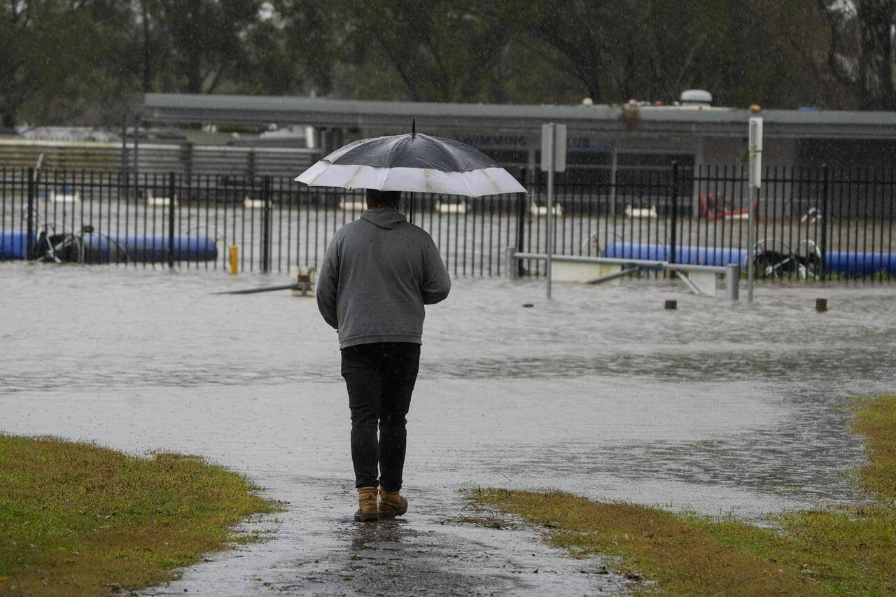A man looks at a flooded sports venue in Camden on the outskirts of Sydney, Australia, Monday, July 4, 2022. More than 30,000 residents of Sydney and its surrounds have been told to evacuate or prepare to abandon their homes on Monday as Australia’s largest city braces for what could be its worst flooding in 18 months. (AP Photo/Mark Baker)