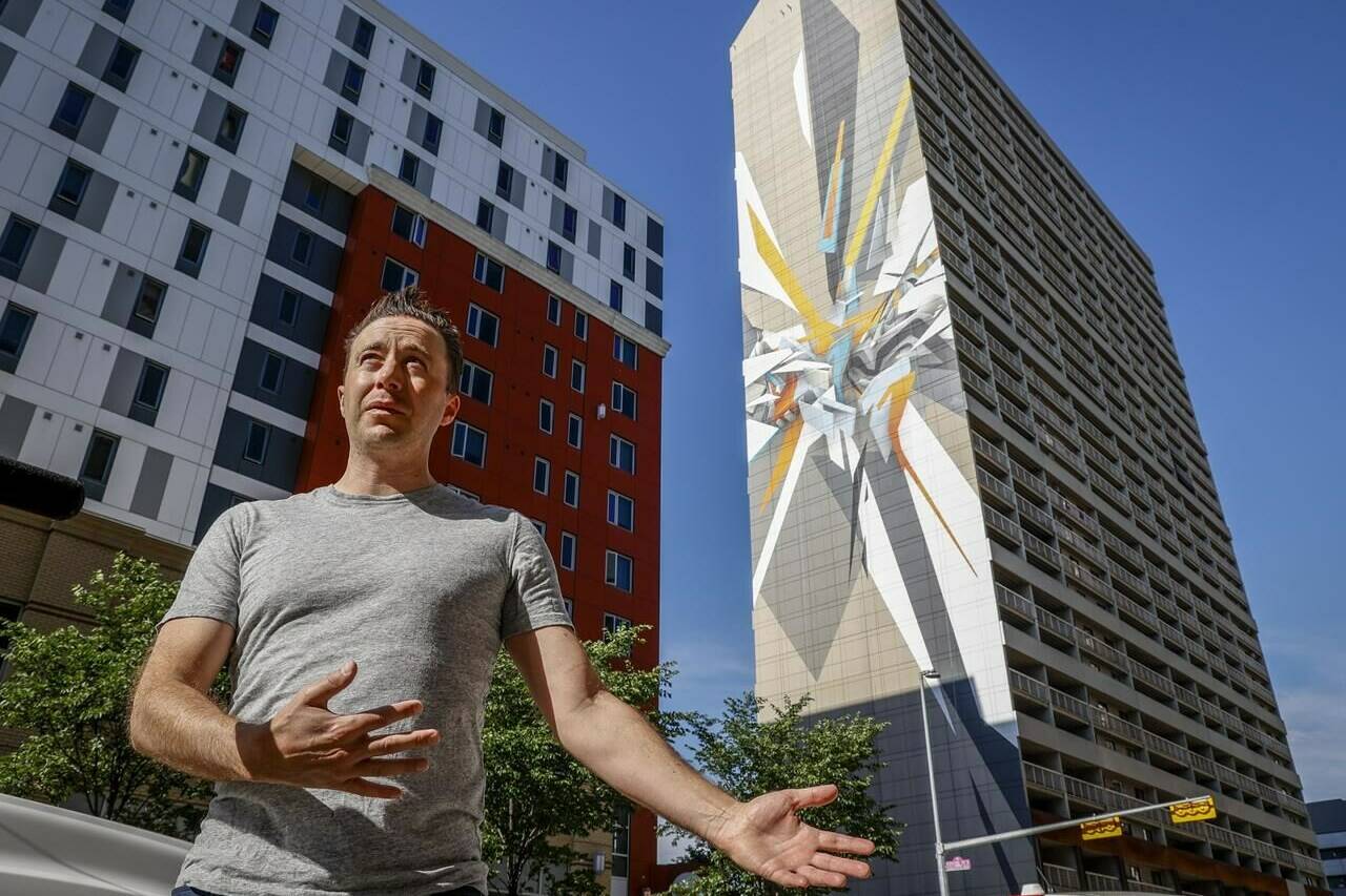 Peter Oliver, co-founder of the Beltline Neighbourhoods Association, gestures as he is interviewed about internationally renowned graffiti artist Mirko Reisser’s creation of the world’s tallest mural in Calgary, Tuesday, June 28, 2022. THE CANADIAN PRESS/Jeff McIntosh