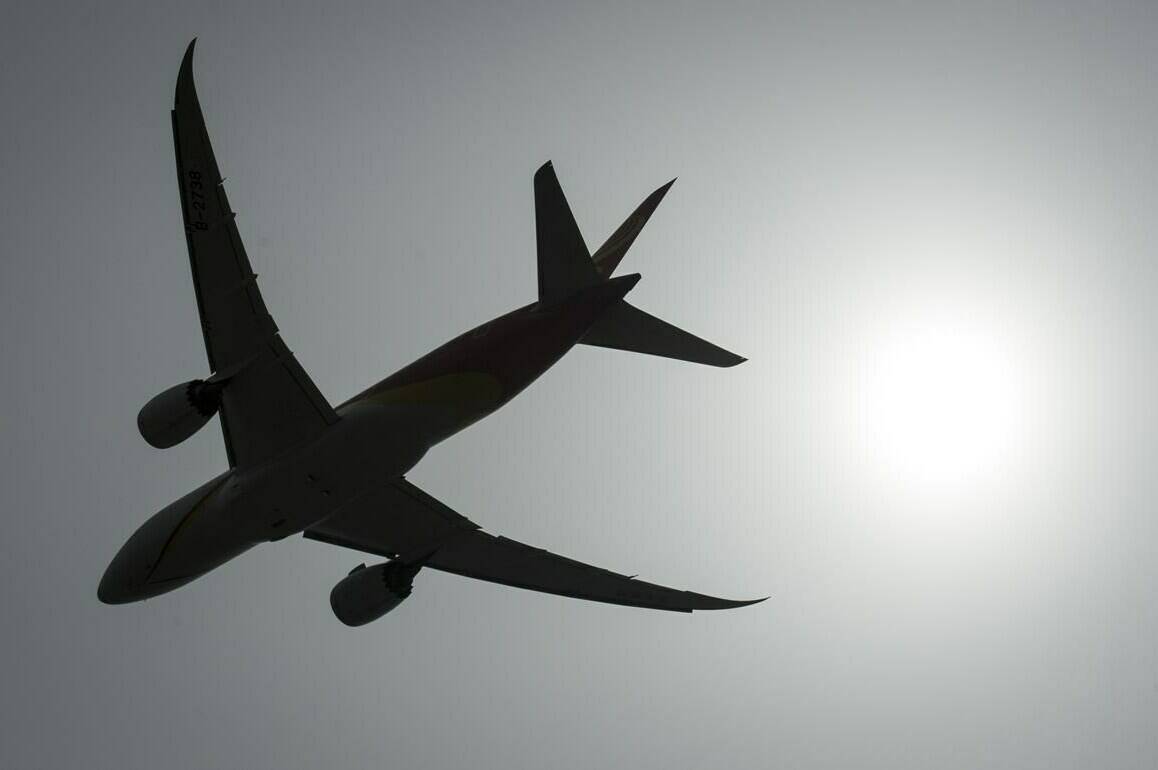 A plane is silhouetted as it takes off from Vancouver International Airport in Richmond, B.C., Monday, May 13, 2019. For those who remain undeterred by the daunting lines and flight delays at Canadian airports, questions remain about how to save money on air travel amid mounting fuel costs and inflation.THE CANADIAN PRESS/Jonathan Hayward