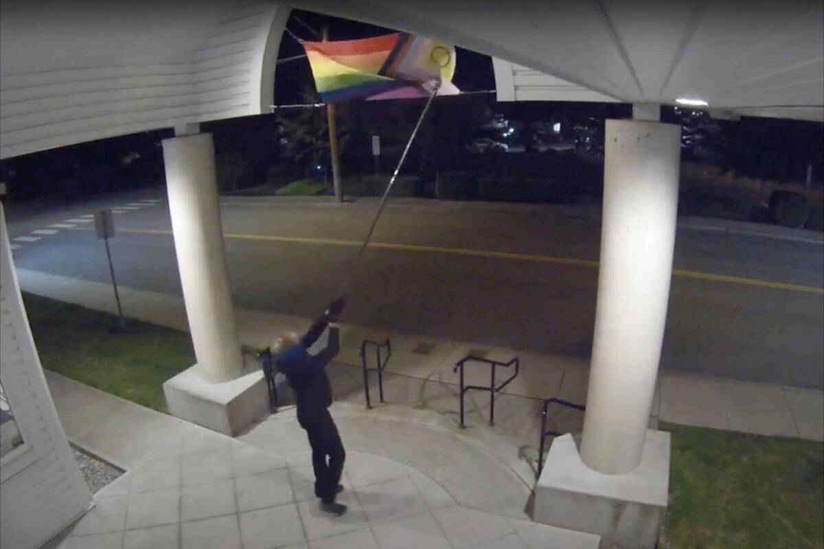 Delta police are hoping the public can help identify a suspect caught on camera defacing a Pride flag outside the entrance to Ladner United Church in the early hours of Tuesday, July 5, 2022. (Delta Police Department video screen shot)