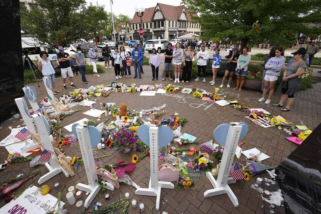 Area residents visit a memorial to the seven people who lost their lives in the Highland Park, Ill., Fourth of July mass shooting, Wednesday, July 6, 2022, in Highland Park. THE CANADIAN PRESS/AP-Charles Rex Arbogast